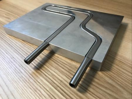 Sertissage d'un tube inox de refroidissement pour un échange thermique optimum avec un bloc aluminium